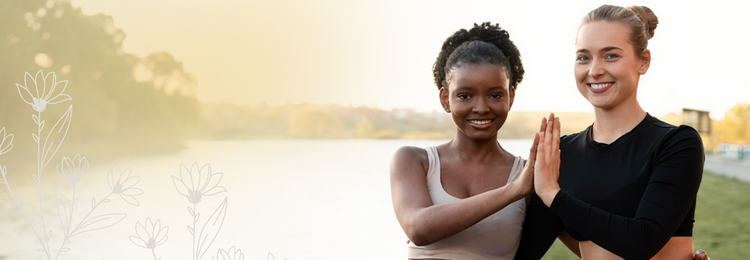 Two women smiling outdoors by a lake – herbal supplements for women's health.